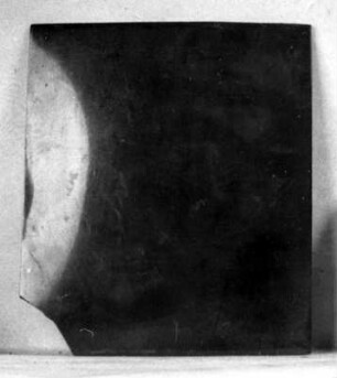Rechteckige Spiegelplatte aus Weißmetall. Oberfläche glänzend schwarz. Eine Ecke weggebrochen