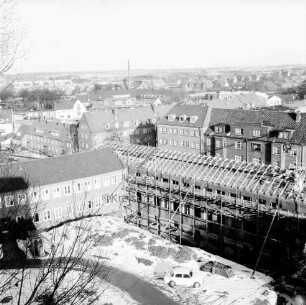 Erweiterungsbau mit Kreistagssitzungssaal [später Gebäude C]: IV. Bauabschnitt: Eindecken des Gebäudes und des Kreistagssitzungssaales: vorn Pkw und Erdhaufen: links Garagentrakt: hinten Wohnblocks an der Mewesstraße und der Reimer-Hansen-Straße: Blick vom Erweiterungsbau "Hochhaus" [später Gebäude B]: Winter