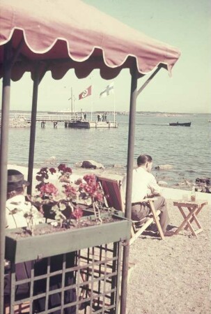 Reisefotos Finnland. Strandcafé. Blick zu einem Bootssteg mit deutscher und finnischer Flagge