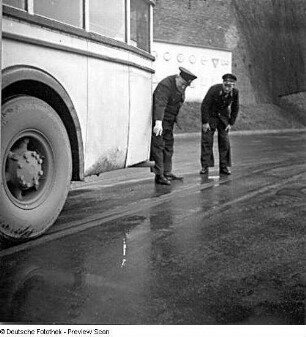 Berlin. Büssing-Doppelstockomnibus (Teilansicht). Zwei Busfahrer betrachten den Auspuff (defekt?)