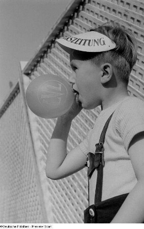 Junge während des Aufblasens eines Luftballons