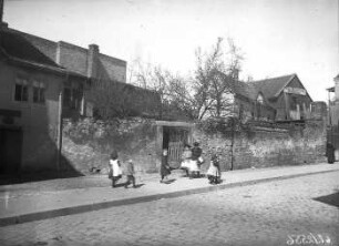Spielende Kinder vor einer Grundstücksmauer