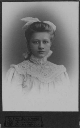 Mädchen mit großer Schleife im Haar : Porträt eines jungen Mädchens mit großer Schleife im Haar. Fotografie (Carte-de-visite mit Atelieraufdruck verso) von Gustav Bodemann in Quakenbrück