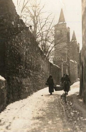 Patschkau (Paczków/Polen), Gasse an der Stadtmauer mit Mauertürmen und zwei Frauen mit Korb
