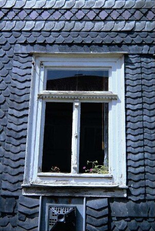 altes verziertes Fenster in Schieferfassade