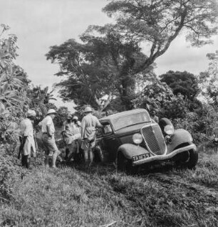 Versunkenes Auto : Männer beim Bergen eines im Schlamm versunkenen Autos