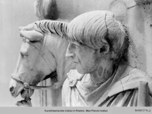 Hochrelief: Mann mit Pferd, darüber zwei Büsten
