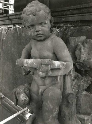 Putto mit Hund und Eichenstamm : Putto mit Hund und Eichenstamm. Sandstein (um 1905). Dresden-Altstadt, Schloßplatz 1, Baustelle Ständehaus (Bauphase Substanzsicherung / Wiederaufbau Dach)
