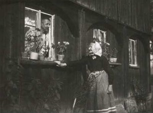 Lausitz. Zwei Alte im Gespräch (Mann, aus dem Fenster eines Umgebindehauses schauend, davor Greisin stehend)