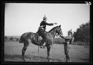 Manöver [in Schwaben:] 1 Offizier zu Pferd und ein das Pferd am Zaum haltender weiterer Offizier (Seitansicht)