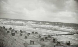 Blick vom Steilufer über den menschenleeren Strand und die Ostsee bei starkem Wellengang