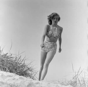 Frau im Bikini mit Sonnenbrille am Strand