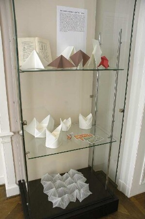 Serviettenfaltkunst. Dresden-Pillnitz, Kunstgewerbemuseum. 2007.06.30-10.31. Standvitrine mit gefalteten Servietten von J. Sallas