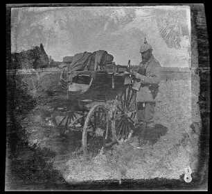 "Baccarat (Dep. Meurthe-et-Moselle, Frankreich)": [Oberleutnant d.R. Strauß] neben einem Wagenkarren stehend bei einer Rast