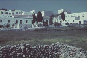 Reisefotos. Gebäudekomplex. Ansicht über eine Feldsteinmauer (vielleicht im Mittelmeerraum)