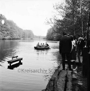 Kupfermühle: Kupfermühlenteich: rechts Bootsanleger mit Ausflüglern: links im Wasser kleiner Steg der Bootsvermietung: hinten Mitte Ruderboot mit vier Jungen: hinten Wald