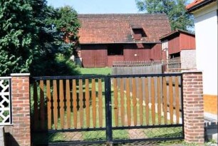 Tor zu einem Grundstück, hinten Scheune