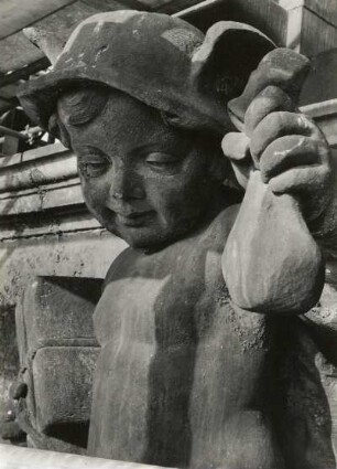 Putto mit Päckchen und Geldbeutel. Um 1905. Sandstein. Figur auf dem Ständehaus, Hüftstück während der Substanzsicherung/Wiederaufbau Dach. Dresden-Altstadt, Schloßplatz 1