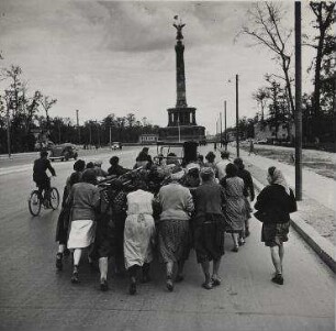 GERMANY Women pushing wagon
