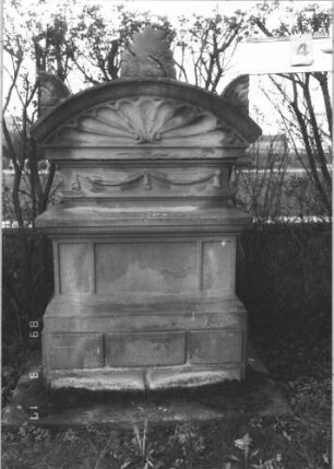 Grabstein 4 (Index: 99808586) Material: Sandstein Zustand: nur Sockel und Giebel erhalten Maße HxBxT: 143x75x42 cm Beschreibung: getreppter Sockel, Segmentbogengiebel mit Akroteren Symbolik: Konche: Grabstein 4