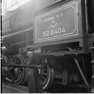 Reparaturschlosser an der Güterzuglokomotive 52 6404 : Berlin-Tempelhof. Reichsbahnausbesserungswerk (RAW). Reparaturschlosser an der Güterzuglokomotive 52 6404. Führerhaus mit russischer Beschriftung "Kolonne Nr.6"