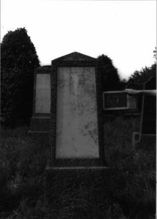 Grabstein 67 (Index: 100100732) Material: Granit, weiße Marmorplatte Zustand: gut Maße HxBxT: 166x48x19 cm Beschreibung: Obelisk, Sockel, Schriftplatte: Grabstein 67