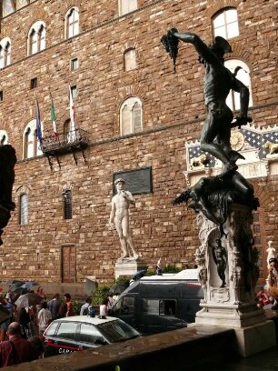 Blick aus der Loggia dei Lanzi, rechts die Figur des "Perseus" mit dem Haupt der Medusa, auf den Palazzo Vecchio mit der Figur des David (Kopie)
