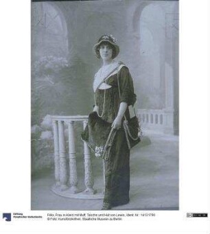 Frau in Kleid mit Muff, Tasche und Hut von Lewis