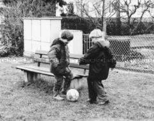 Zwei fußballspielende kleine Jungen (Altersgruppe 14-17)