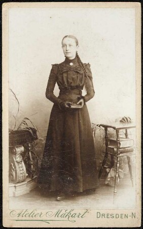 Portrait Mädchen im langen schwarzen Kleid, vermutlich eine Konfirmandin