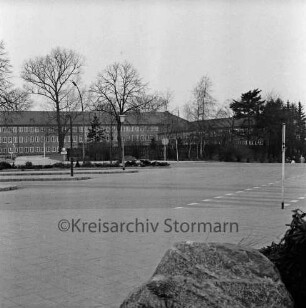 Haupthaus [später Gebäude A]: Mommsenstraße: rechts Anbau mit Garagentrakt: davor Innenhof und Bäume: vorn Bahnhofsvorplatz mit Busbahnhof und Fußgängerüberweg