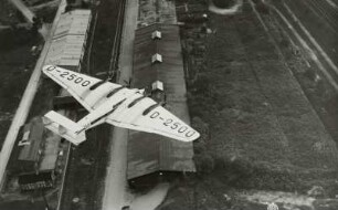 Viermotoriges Verkehrsflugzeug Junkers G38 im Flug über Rangier- und Verladeanlagen