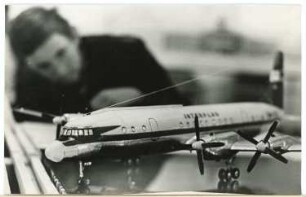 Mann betrachtet Flugzeugmodell