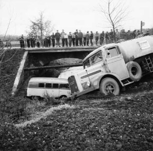 Verkehrsunfall: Kalkgraben / Einmündung in Hamburger Chaussee - B 75 / Brücke über Heilsau: Zementlastwagen schräg auf Böschung: Wäscherei-Lieferwagen in Heilsau: hinten Brücke der B 75, an Brückengeländer Zuschauer, links angelehntes Fahrrad, rechts Wegweiser