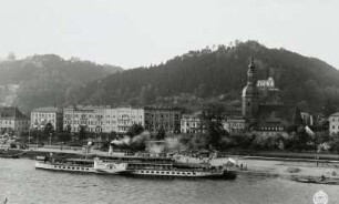 Personen-Seitenraddampfer "Leipzig" (1929; Werft Dresden-Laubegast) beim Fahrgastwechsel an der Landungsbrücke : Bad Schandau. Personen-Seitenraddampfer "Leipzig" (1929; Werft Dresden-Laubegast) beim Fahrgastwechsel an der Landungsbrücke. Blick vom linken Uferhang über die Elbe auf Hotelbauten und Stadtkirche