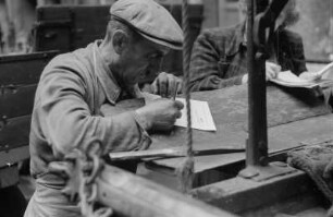 Reportage: Berliner Männer und Frauen tragen sich für die Ächtung der Atombomben ein : Arbeiter trägt sich in die Unterschriftenliste ein
