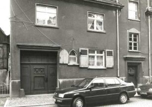 Radeburg, August-Bebel-Straße 4/6. Doppelwohnhaus (um 1910). Teilansicht der Fassade mit Tordurchfahrt und Haustür