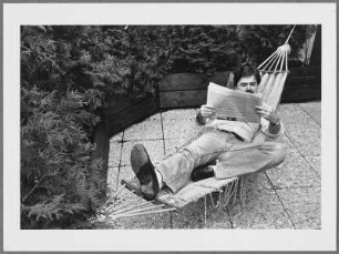 Peter Gauweiler, CSU München, zeitungslesend in einer Hängematte liegend auf einer Terrasse