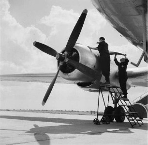 Leipzig-Mockau. Flughafen, Vorfeld. Zwei Techniker bei Wartungsarbeiten an einem Flugzeugmotor