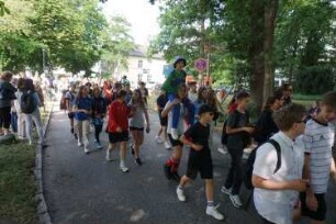 Bad Oldesloe: Kindervogelschießen: Am Bürgerpark, Blickrichtung Westen: Einzug auf den Exer: Festumzug Theodor-Mommsen-Schule Klasse 7b, teils mit Verkleidung: im Hintergrund Jugendfreizeitstätte (JuZe): 13. Juli 2023