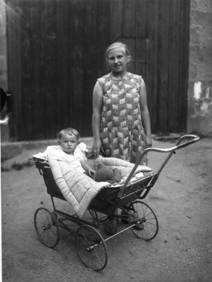 Mutter (?) mit Kind im Kinderwagen