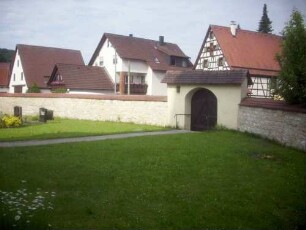 Kirchhof im Westen mit Kirchhofmauer (Wehrgang mit Steinbrüstung im 18 Jh abgetragen) und neuem Zugang (18 Jh) in Übersicht