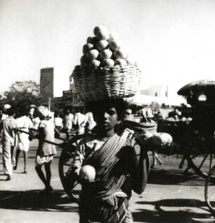 Indien. Inder aus Madras, Korb mit Obst auf dem Kopf tragend