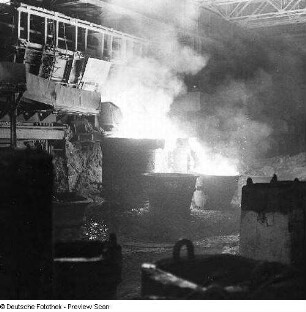 Brandenburg an der Havel. VEB Stahl- und Walzwerk Brandenburg. Gießhalle. Abstich eines Siemens-Martin-Ofens, vor dem Ofen die Gießpfanne, im Vordergrund die Gießformen (Kokillen)