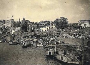 Varanasi (Benares), Indien. Stadtteilansicht mit Tempelanlagen. Blick vom Ganges zum Ufer mit Gläubigen