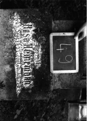 Grabstein 49 (Index: 100101019) Material: Sandstein, neue Platte Zustand: Schrifttafel fehlt, Sockel verwittert Maße HxBxT: 152x45x23 cm Beschreibung: Stele, Sockel, Abdeckplatte mit rechteckigem Aufsatz und seitlichen Voluten, eingetieft. Schriftfeld rechteckig Symbolik: Voluten Besonderheit: eingemeißelte Nummer: 36: Grabstein 49A