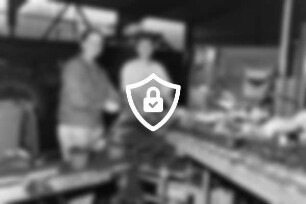 Großgärtnerei BLUDA: Gärtnereihalle: Angestellte bei der Arbeit an einer Pflanzmaschine mit Setzlingen