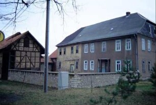 Natursteinmauer als Hofabgrenzung; hinten Wohnhaus