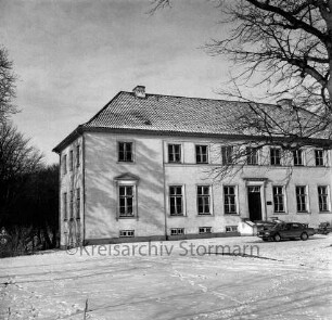Gut Altfresenburg: das Herrenhaus im Winter: Ansicht der Vorderfront, rechts ein parkender Pkw