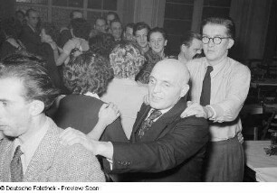 Gäste einer Betriebsweihnachtsfeier beim Tanzen einer Polonaise